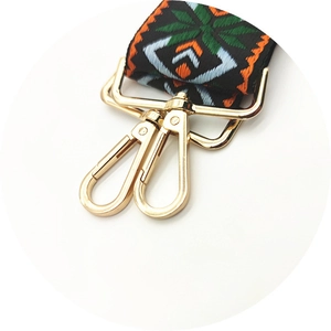 Detailed close-up of bohemian embroidery strap with gold metal lobster clasps