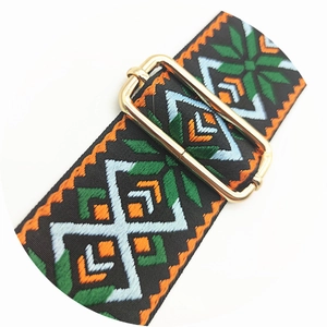Macro detail of ethnic embroidered wide bag strap with golden metal adjustment buckle
