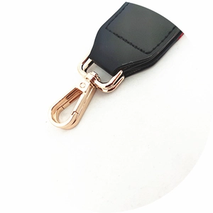Close-up of black leather bag strap end with high-quality gold metal lobster clasp