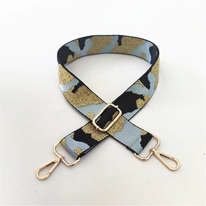 Detail of adjustable camo shoulder strap with gold metal hooks and glitter weave
