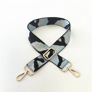 Detail of adjustable camouflage bag strap with blue silver weaving and gold hardware