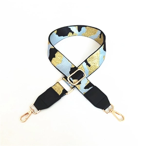 Detail of adjustable wide camouflage strap with gold glitter patterns and metal hooks