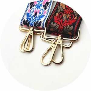 Detail of colorful jacquard embroidery bag straps with glossy golden metal lobster clasps