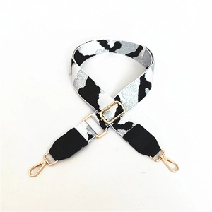 Detail of adjustable leopard print bag strap with golden metal lobster clasps and buckles