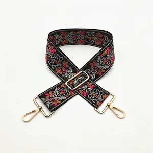 Close-up of adjustable ethnic embroidery shoulder strap with gold lobster claw clasps