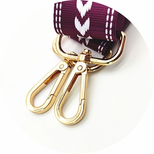 Detail of adjustable purple woven strap with golden lobster clasps for handbags