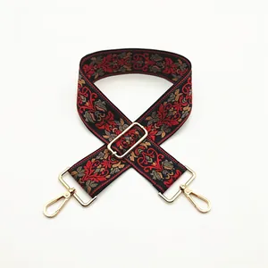 Detailed view of ethnic embroidery purse strap with golden metal buckles and floral pattern