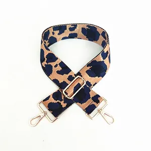 Detail of adjustable leopard print bag strap with golden metal lobster clasps and buckle