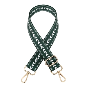 Detail of dark green woven bag strap with white V-pattern and gold metal hardware
