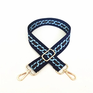 Adjustable dark blue jacquard shoulder strap with geometric chain pattern and gold hooks