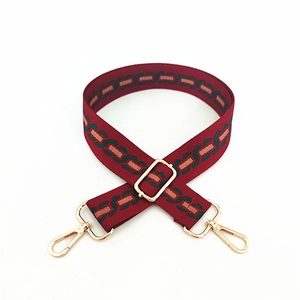 Adjustable dark red shoulder strap with geometric chain patterns and gold lobster clasps