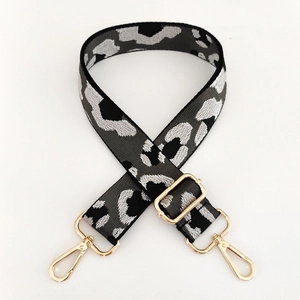Detail of adjustable leopard print bag strap with polished gold-tone metal hooks