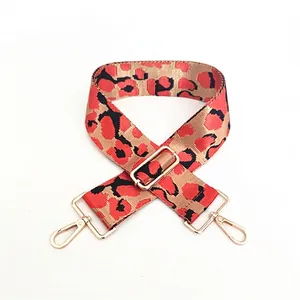 Macro view of adjustable leopard print bag strap with golden metal lobster clasps