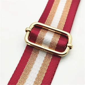 Détail de la bandoulière réglable à rayures rouge vin et or avec boucle métallique