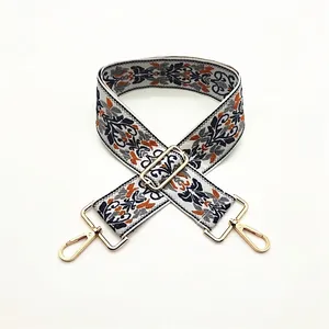 Close-up of adjustable ethnic embroidered bag strap with golden metal lobster clasps