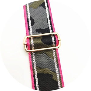 Detail of camouflaged bag strap featuring a polished gold adjustable metal buckle