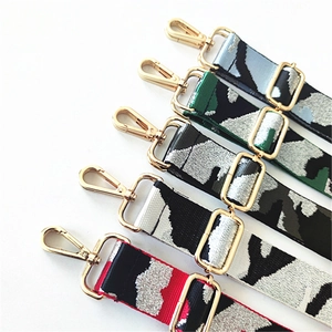 Detail of adjustable wide camouflage fabric bag straps with gold metal lobster clasps