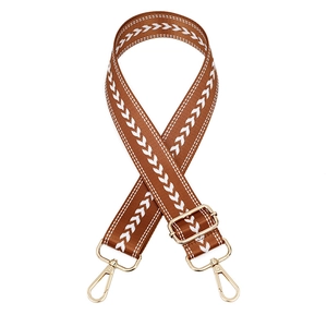 Close-up of brown adjustable bag strap with white arrow pattern and gold metal hardware