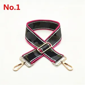 Detail of adjustable wide camouflage strap with pink edges and gold metal buckles