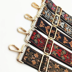 Close-up of ethnic style jacquard guitar bag straps with gold metal hooks and buckles