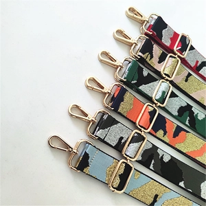 Detail view of multi-color camo woven bag straps with gold metal hooks and adjusters