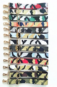 Detail showing multi-color camouflage and geometric wide fabric straps with gold hardware