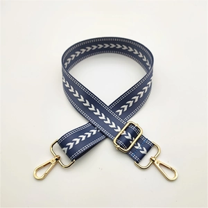Close-up of adjustable navy blue chevron woven shoulder strap with gold lobster clasps