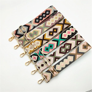 Detailed view of bohemian geometric woven purse straps with gold metal hardware adjusters