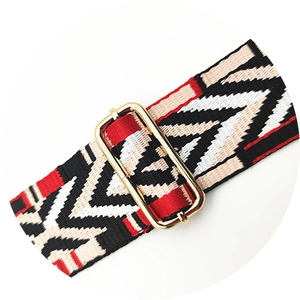 Detail of colorful geometric jacquard bag strap with adjustable gold metal buckle