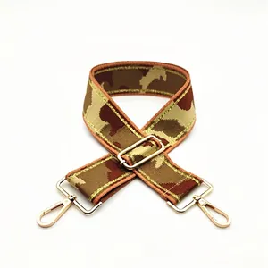 Detail of adjustable camouflage bag strap with wide webbing and gold swivel metal hooks