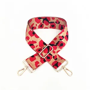 Detail of adjustable leopard print bag strap with golden metal lobster clasps and buckles