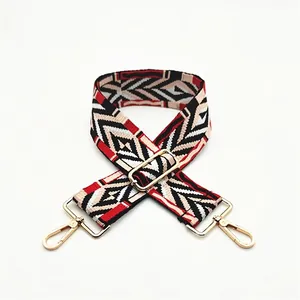 Detailed view of adjustable wide ethnic bag strap with geometric patterns and gold clips