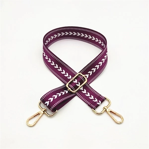 Detail view of purple adjustable herringbone purse strap with golden metal snap hooks