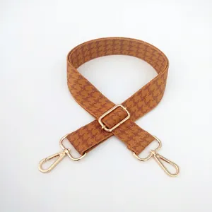 Detail of adjustable houndstooth shoulder strap with gold metal lobster clasps