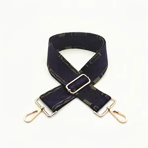 Detail of woven wide shoulder strap with ethnic pattern and gold metal buckles