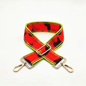 Close-up of wide camouflage jacquard bag strap with neon green trim and gold alloy buckles