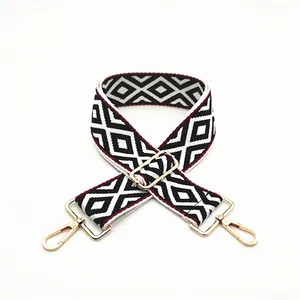 Detail of geometric rhombus pattern bag strap with gold metal lobster clasps and buckles