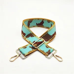 Macro detail of adjustable camouflage canvas strap with gold metal buckle and swivel hooks