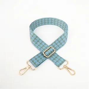 Adjustable houndstooth bag strap with light blue and grey patterns and gold hardware