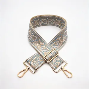 Close-up of adjustable paisley ethnic strap with golden hardware and lobster clasps
