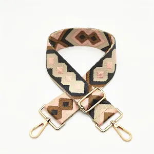 Close-up of bohemian style geometric diamond pattern woven bag strap with gold buckle