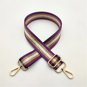 Détail de la sangle en nylon rayée violet et or réglable avec mousquetons dorés