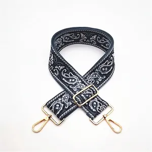 Detailed view of paisley pattern woven purse strap with gold metal lobster clasps