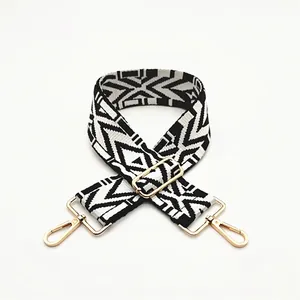 Detail view of ethnic black and white geometric pattern wide strap with gold metal hardware