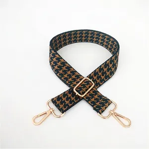 Detail of adjustable houndstooth shoulder strap with high-quality gold metal hooks