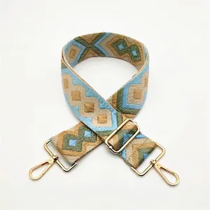 Detail of ethnic geometric woven strap with gold metal lobster clasps and buckles