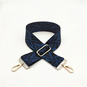 Macro shot of durable adjustable bag strap with blue geometric patterns and gold metal clips