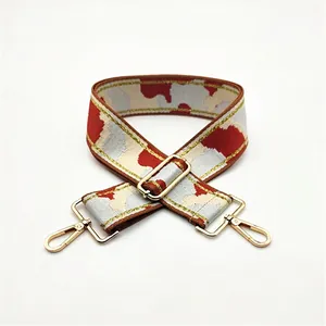 Detailed macro view of camo jacquard strap with gold metallic thread and hardware