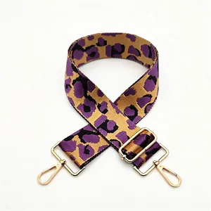Detail of purple and blue leopard print wide adjustable strap with gold metal swivel hooks