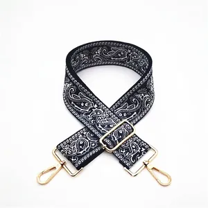 Detail view of thickened adjustable woven bag strap with white paisley print and gold clasps